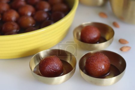 Photo for Delectable Gulab Jamun dessert on a rustic plate. Close up of golden fried milk balls in sweet syrup. Indian sweets, traditional delicacy. Festive, delicious, indulgent celebration confectionery - Royalty Free Image