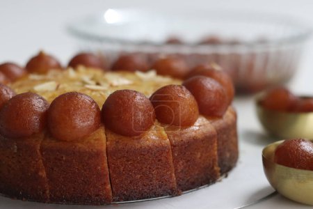 Téléchargez les photos : Gâteau Gulab Jamun décoré d'un jamun gulab sur le dessus. Dessert fusion irrésistible, combinant des saveurs de bonbons indiens traditionnels avec l'indulgence d'un gâteau humide. Parfait pour les célébrations festives - en image libre de droit