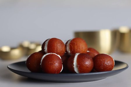 Photo for Malai Gulab Jamun. Gulab Jamun sandwich with milk cream filling. Fusion of Indian sweet dessert, golden brown, soft, and soaked in sugar syrup. Perfect for celebrations, festivals, and indulgence. - Royalty Free Image