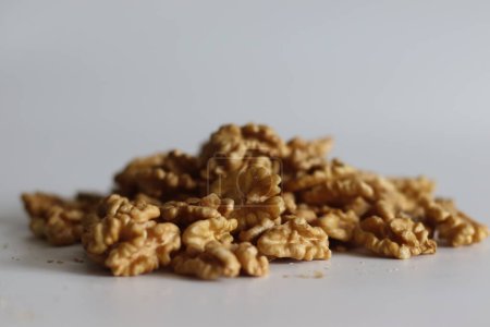 Pristine pile of premium dry walnuts, ideal for culinary creations and healthy snacks. Nut lovers rejoice in this bountiful harvest. Rustic, organic. Shot on white background