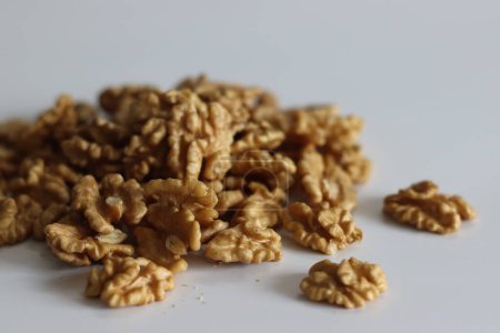 Pristine pile of premium dry walnuts, ideal for culinary creations and healthy snacks. Nut lovers rejoice in this bountiful harvest. Rustic, organic. Shot on white background