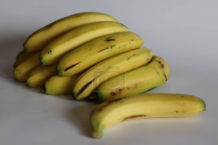 Plátano Robusta. Vibrante racimo de una docena de plátanos Robusta, maduros y abundantes. Perfecto para un estilo de vida saludable, frutas tropicales, bocadillos orgánicos y conceptos de frescura de la granja. Disparo sobre fondo blanco