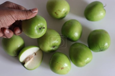 Ber apple oder Juju Be. Lebendiges Bild des Juju Be Apfels, das seine Textur und satte Farbe sowohl innen als auch außen zur Geltung bringt. Perfekt für Themen in den Bereichen Gesundheit, Ernährung und Obst. Schuss auf weißem Hintergrund