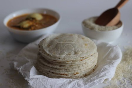 Reis Roti serviert mit Ei-Curry. Eine glutenfreie Alternative mit rohem Reis vier, perfekt für eine gesunde Mahlzeit. Indische Küche, Fladenbrot, Vollkornprodukte, traditionelles Ernährungskonzept. Schuss auf weißem Hintergrund