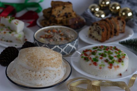 Christmas day breakfast spread prepared in kerala style on the table along with Christmas decorations. Appam, chicken stew, vattayappam, Cranberry orange bundt cake and fruit cake.