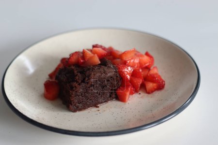 Chocolate brownies. Indulge in decadent chocolate brownies paired with fresh strawberries, perfect for dessert lovers, food bloggers, and culinary enthusiasts. Featuring Eggless preparation of brownie