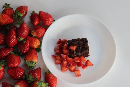 Schokoladenbrownies. Verwöhnen Sie sich mit dekadenten Schokoladenbrownies gepaart mit frischen Erdbeeren, perfekt für Dessertliebhaber, Food-Blogger und kulinarische Enthusiasten. Eifreie Zubereitung von Brownie