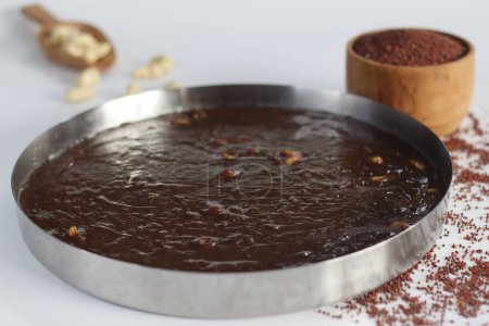 Delectable Ragi Halwa in round steel plate mold, Indian dessert, nutritious, vegan, gluten-free, sweet, perfect for foodies and health-conscious. Halwa made with finger millet flour and cashews