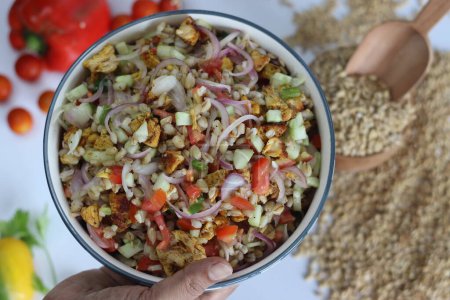 Hulled barley chicken salad. Hearty salad with hulled barley, chicken, cucumber, tomato, onions in a ceramic bowl. Healthy, nutritious, delicious meal for food lovers. Shot on white background
