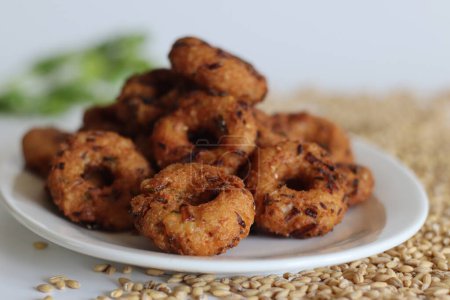 Barley Vada or fritters. Golden fried hulled barley vadas, crispy, healthy, vegetarian snack, Indian cuisine, perfect for foodies and culinary enthusiasts. Shot on white background.