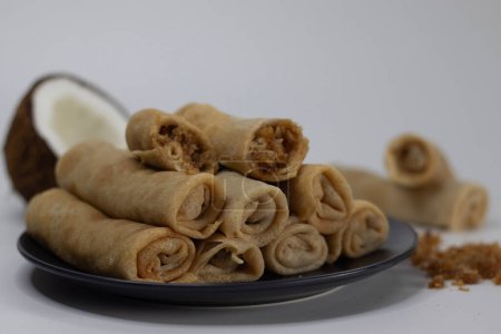 Coconut jaggery crepes. South Indian cuisine, sweet dessert, perfect for foodies and culinary enthusiasts. Pancake made of wheat flour, egg and milk, rolled with coconut jaggery mix in the center