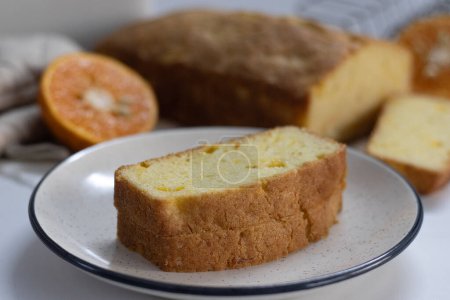 Scheiben von Orangen-Pfund-Kuchen, auch als Zitrusbrot-Kuchen oder Orangen-Butter-Kuchen bekannt. Feuchtes, würziges Dessert mit würziger Glasur, perfekt für Feinschmecker, Backenthusiasten und für süße Gelüste