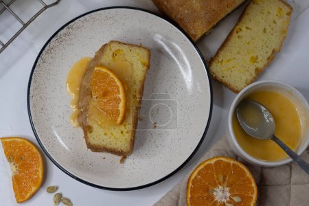 Rebanadas de pastel de libra de naranja, también conocido como pastel de pan cítrico o pastel de mantequilla de naranja. Postre húmedo, sabroso, con glaseado picante perfecto para los amantes de la comida, entusiastas de la cocción, y para los antojos dulces
