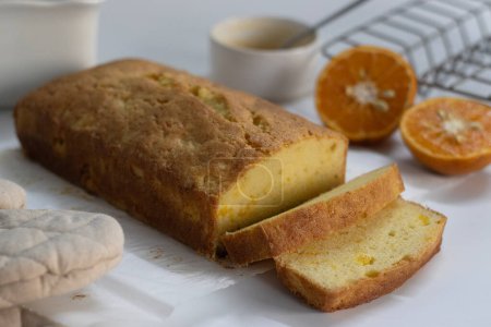 In Scheiben geschnittener Laib Orangenpfundkuchen, auch als Zitruslaibchen oder Orangenbutter-Kuchen bekannt. Feuchtes, würziges Dessert mit würziger Glasur, perfekt für Feinschmecker, Backenthusiasten und für süße Gelüste