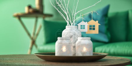 Téléchargez les photos : Aromatic reed air freshener and scented candle on table indoors. green living room and sofa background. 3d rendering and illustration. - en image libre de droit