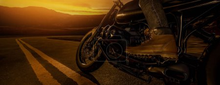Foto de Una vista lateral cercana de un motociclista clásico en la carretera. Por la noche, cuando el sol se ponía, 3d representaciones e ilustraciones. - Imagen libre de derechos