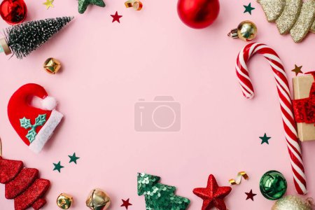 Christmas flat lay. Stylish christmas festive decorations, confetti, trees frame on pink background. Creative seasons greeting card, space for text. Merry Christmas and Happy Holidays!