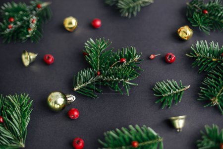 Foto de Banner de Navidad moderno. Elegantes ramas de árbol de Navidad, bayas rojas y composición de bolas de oro sobre fondo negro. Vacaciones de invierno. Feliz Navidad y Felices Fiestas - Imagen libre de derechos