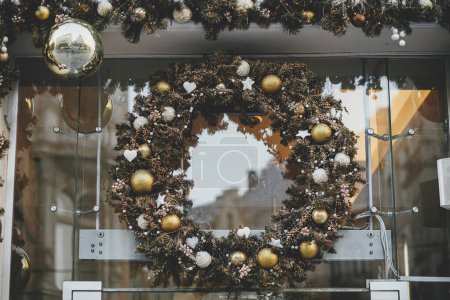 Foto de Corona de Navidad con estilo con bolas de plata y oro en el exterior del edificio. Decoración moderna de Navidad en la calle de la ciudad. Vacaciones de invierno en Europa. Feliz Navidad. - Imagen libre de derechos