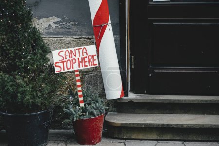 Foto de Elegante bastón de caramelo grande y signo de Santa parada aquí en el exterior del edificio. Decoración moderna de Navidad en la calle de la ciudad. Vacaciones de invierno en Europa. Decoraciones festivas - Imagen libre de derechos