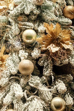 Foto de Elegante árbol de Navidad con adornos dorados de cerca en la noche. Decoración moderna de Navidad en la calle de la ciudad. Vacaciones de invierno en Europa. Feliz Navidad y Felices Fiestas - Imagen libre de derechos
