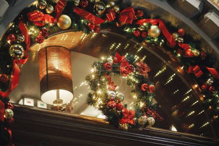 Photo for Stylish christmas wreath with golden lights and ornaments in evening. Modern christmas decor in city street. Atmospheric winter holidays in Europe. Merry Christmas and Happy Holidays - Royalty Free Image