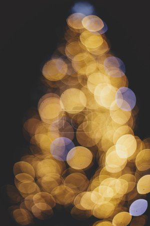 Photo for Blurred christmas tree golden festive lights in evening. Abstract christmas tree, illumination bokeh. Atmospheric winter holidays. Merry Christmas and Happy Holidays - Royalty Free Image