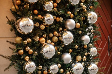 Foto de Elegantes ramas de abeto de Navidad con adornos de oro y plata en el exterior del edificio. Decoración moderna de Navidad en la calle de la ciudad. Vacaciones de invierno en Europa. ¡Feliz Navidad! Fondo de pantalla festivo - Imagen libre de derechos