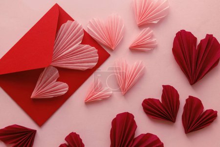Téléchargez les photos : Happy Valentine's day! Stylish pink hearts and red envelope flat lay on pink paper background. Modern Valentines day composition. Love letter concept. - en image libre de droit