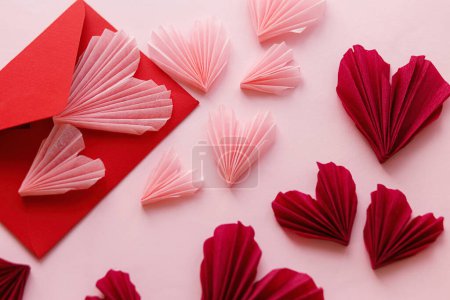 Téléchargez les photos : Stylish pink hearts and red envelope flat lay on pink paper background. Happy Valentine's day! Modern Valentines day composition. Love letter concept. - en image libre de droit