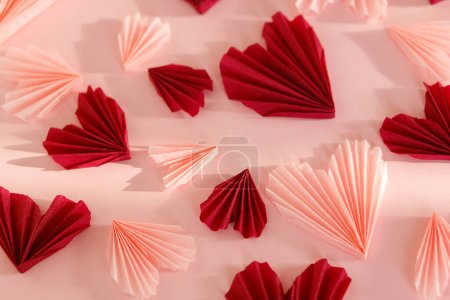 Téléchargez les photos : Happy Valentine's day. Stylish pink and red hearts composition on pink paper background. Creative modern valentines hearts cutouts. Love background. - en image libre de droit