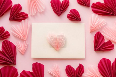 Téléchargez les photos : Valentines day flat lay. Stylish envelope with pink and red hearts composition on pink paper background. Creative modern valentine hearts cutouts. Happy Valentine's day! Love letter - en image libre de droit