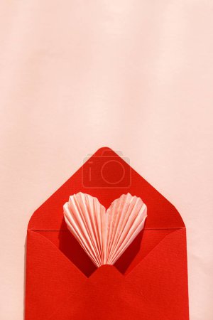 Téléchargez les photos : Happy Valentine's day! Stylish red envelope with pink heart flat lay on pink paper background. Modern valentine card template, space for text. Love banner. Creative letter composition - en image libre de droit