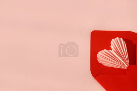 Foto de Happy Valentine's day! Stylish red envelope with pink heart flat lay on pink paper background. Modern valentine card template, space for text. Love banner. Creative letter composition - Imagen libre de derechos