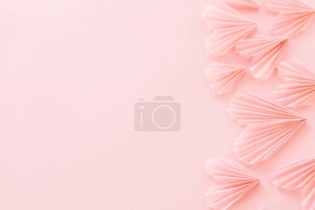 Téléchargez les photos : Happy Valentine's day! Stylish pink hearts on pink paper background. Modern cute valentine hearts cutouts, card with space for text. Creative love banner - en image libre de droit