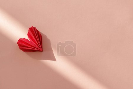 Photo for Happy Valentine's day! Stylish red heart in sunlight on pink paper background flat lay. Modern cute valentine heart cutout, space for text. Creative love banner - Royalty Free Image