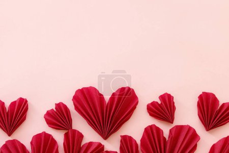 Téléchargez les photos : Valentines day flat lay. Stylish red hearts composition on pink paper background with space for text. Happy Valentine's day! Modern cute valentine heart cutouts. Creative love banner - en image libre de droit