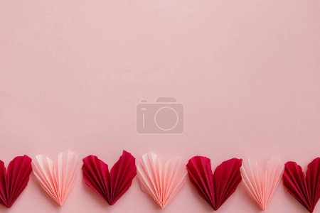 Téléchargez les photos : Valentines day flat lay. Stylish red and pink hearts composition on pink paper background with space for text. Happy Valentine's day! Modern cute valentine heart cutouts. Creative banner - en image libre de droit