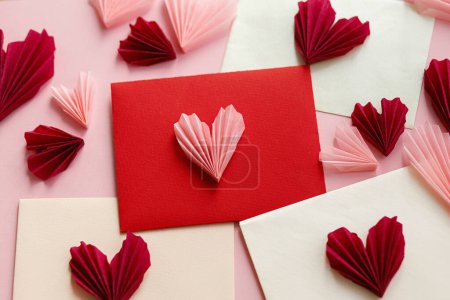 Foto de Happy Valentine's day! Stylish envelopes with pink and red hearts flat lay on pink paper background. Creative modern valentine hearts cutouts composition. Love letter - Imagen libre de derechos