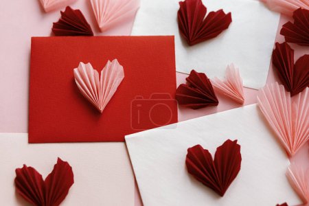 Téléchargez les photos : Valentines day flat lay. Stylish envelopes with pink and red hearts composition on pink paper background. Creative modern valentine hearts cutouts. Happy Valentine's day! Love letter - en image libre de droit