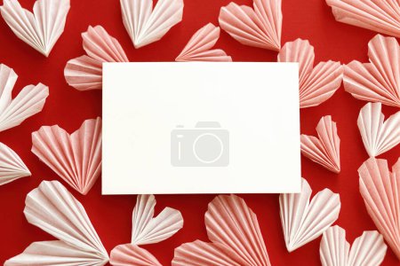Téléchargez les photos : Empty card and stylish red and pink hearts flat lay on red paper background. Creative modern valentines greeting card mock up with space for text. Happy Valentine's day! Love letter - en image libre de droit