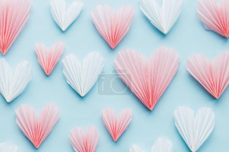 Téléchargez les photos : Valentines day flat lay. Stylish pink and white hearts composition on blue paper background. Happy Valentine's day! Modern cute valentine heart cutouts. Creative love banner - en image libre de droit