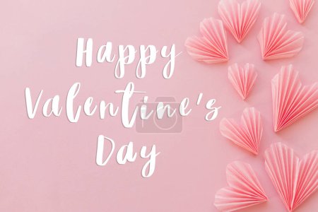 Téléchargez les photos : Happy valentines day text on cute pink hearts flat lay on pink paper background. Modern Valentines day greeting card. Handwritten sign. Heart border - en image libre de droit