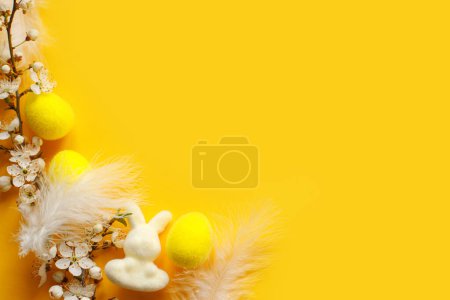 Foto de ¡Feliz Pascua! Pascua plana poner con huevos, conejo, plumas y cerezo en flor sobre fondo amarillo. Plantilla festiva moderna con espacio para texto. Tarjeta de felicitación o banner - Imagen libre de derechos