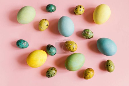 Foto de Pascuas planas. Elegantes huevos de Pascua sobre fondo rosa. ¡Feliz Pascua! Composición natural de huevos coloridos pintados. Tarjeta de felicitación moderna o banner - Imagen libre de derechos