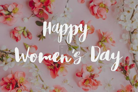 Téléchargez les photos : Happy womens day text and stylish spring flowers composition on pink background flat lay. Floral Greeting card. Handwritten sign. 8 march international women's day - en image libre de droit