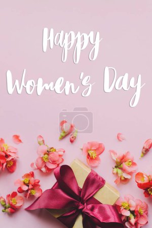Téléchargez les photos : Happy womens day text et élégant coffret cadeau avec des fleurs sur fond rose. Carte de vœux. Signes manuscrits et cadeaux pour la Journée internationale de la femme. 8 mars - en image libre de droit