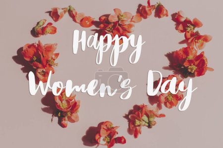 Photo for Happy womens day text and  stylish heart shape with red flowers on pink background flat lay. Floral Greeting card. Handwritten sign. 8 march international women's day - Royalty Free Image