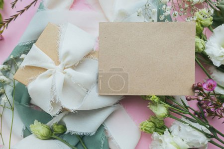 Foto de Elegante tarjeta de felicitación vacía, regalo y hermosas flores sobre fondo rosa planas. Feliz día de la mujer y el concepto del día de la madre. Imagen tierna de primavera. Espacio para texto - Imagen libre de derechos