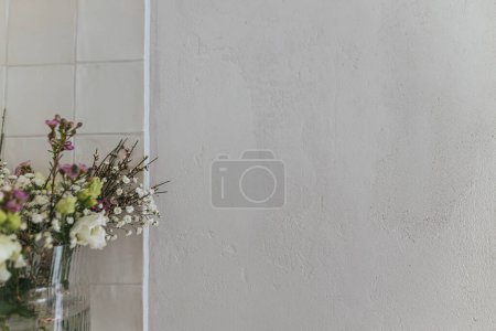 Photo for Stylish spring flowers, eustoma, gypsophila and chamelaucium on background of rustic wall. Floral greetings. Happy women's day and mother's day. Modern bouquet, space for text - Royalty Free Image